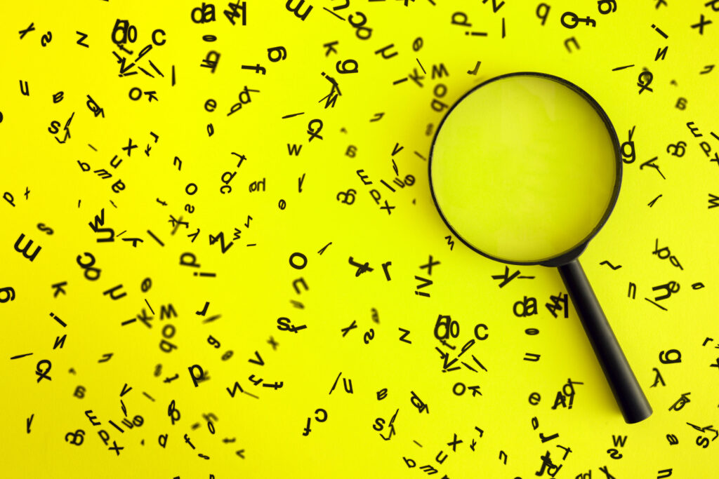 Magnifying glass surrounded by a swarm of black lowercase letters on a neon yellow background, representing SEO crawling and strategy.